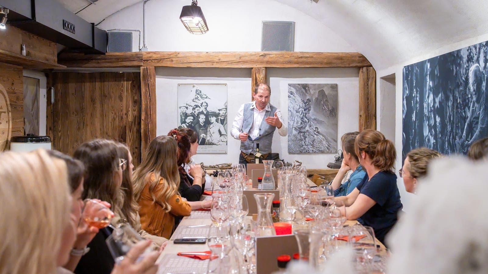 Rainer Zimmermann mit einer Gruppe an einer langen Degustationstafel beim Wein-Event «Auf den Spuren von Johanneli Fi» (Foto: levin.studio)